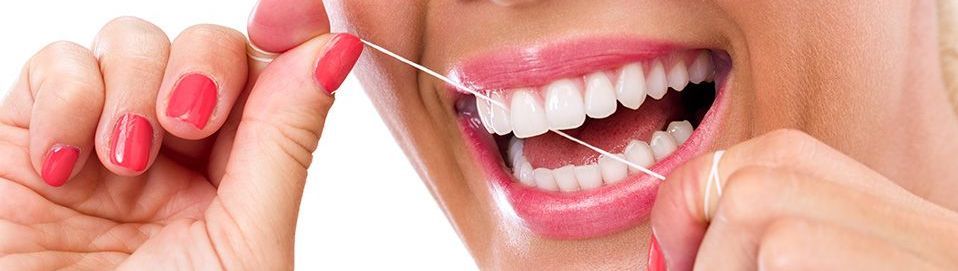 a woman is flossing her teeth with a dental floss .