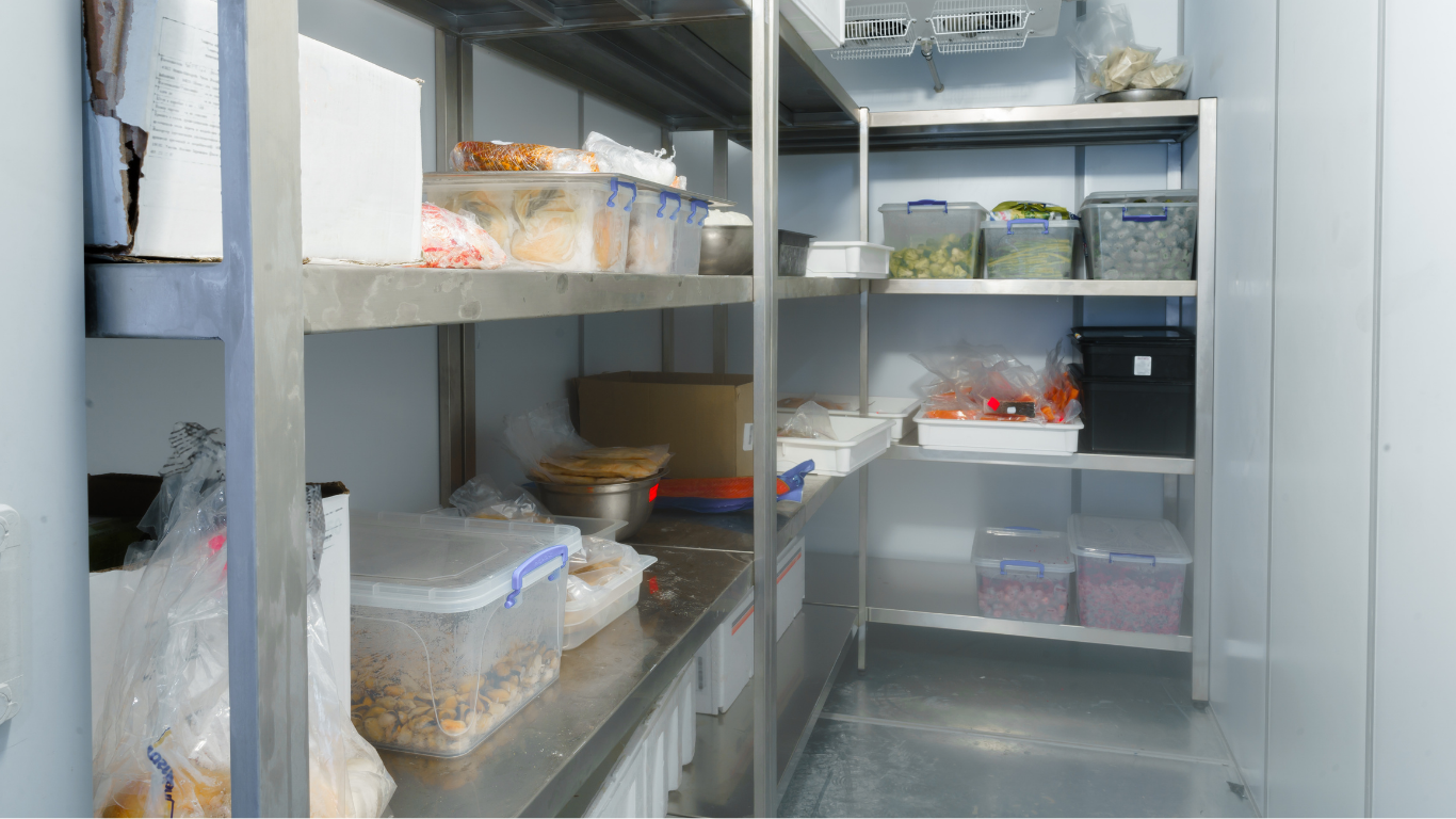 A kitchen with stainless steel shelves filled with food.