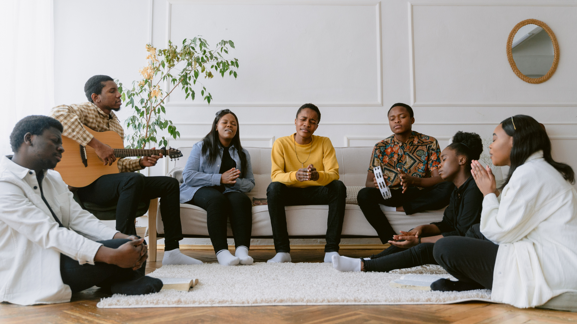 A group of people are sitting in a circle in a living room.