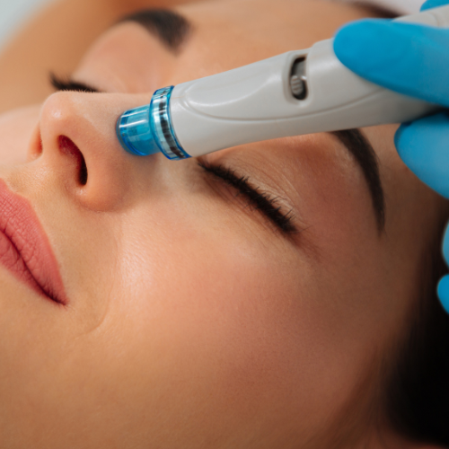 Uma mulher está recebendo um tratamento facial com uma máquina no rosto.