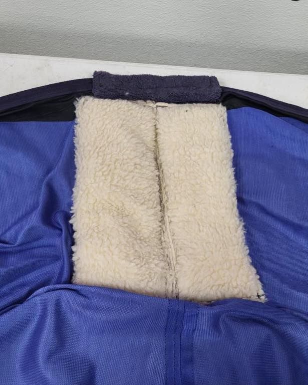 Blue jacket interior with white fuzzy lining, visible at the neck.