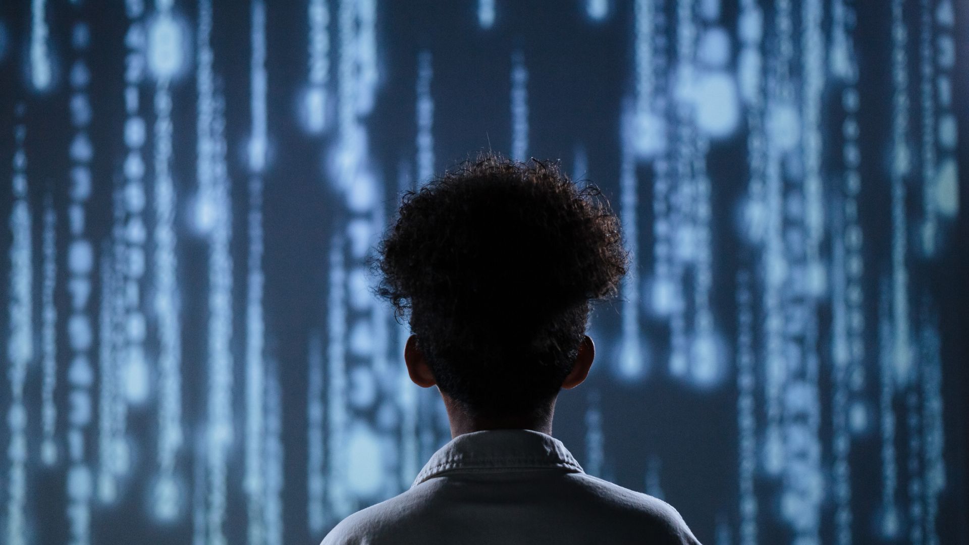 Person facing a glowing blue digital code display.