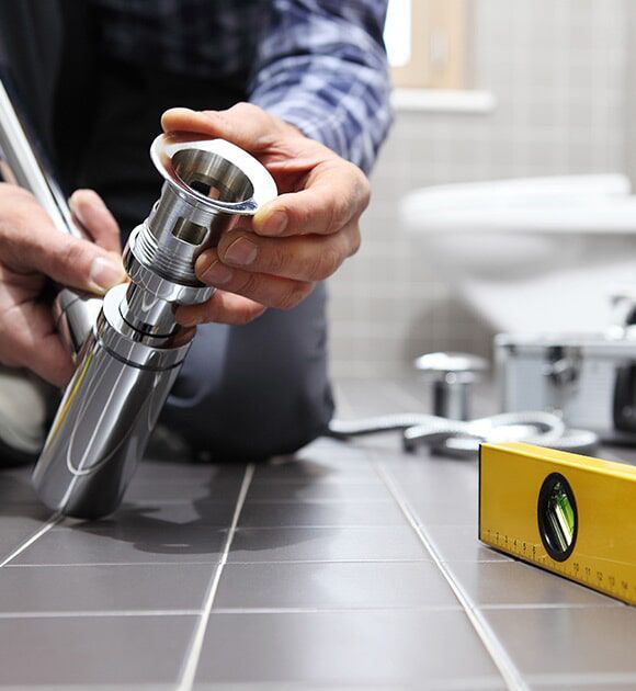 A Plumber Is Working on A Sink in A Bathroom — Plumbers & Gas Fitters in Coconut Grove, NT