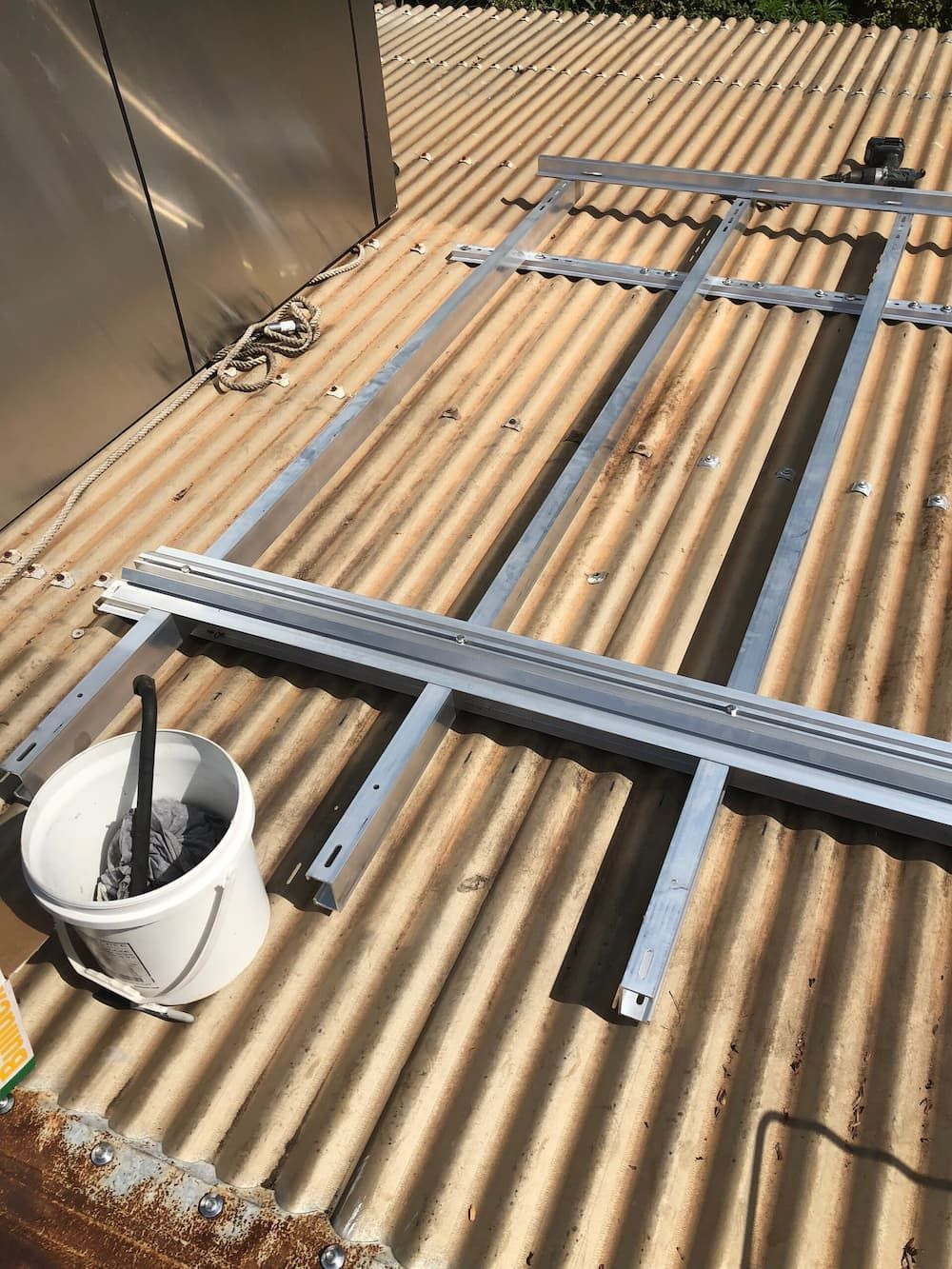 A Metal Frame Is Sitting on Top of A Corrugated Metal Roof — Plumbers & Gas Fitters in Coconut Grove, NT