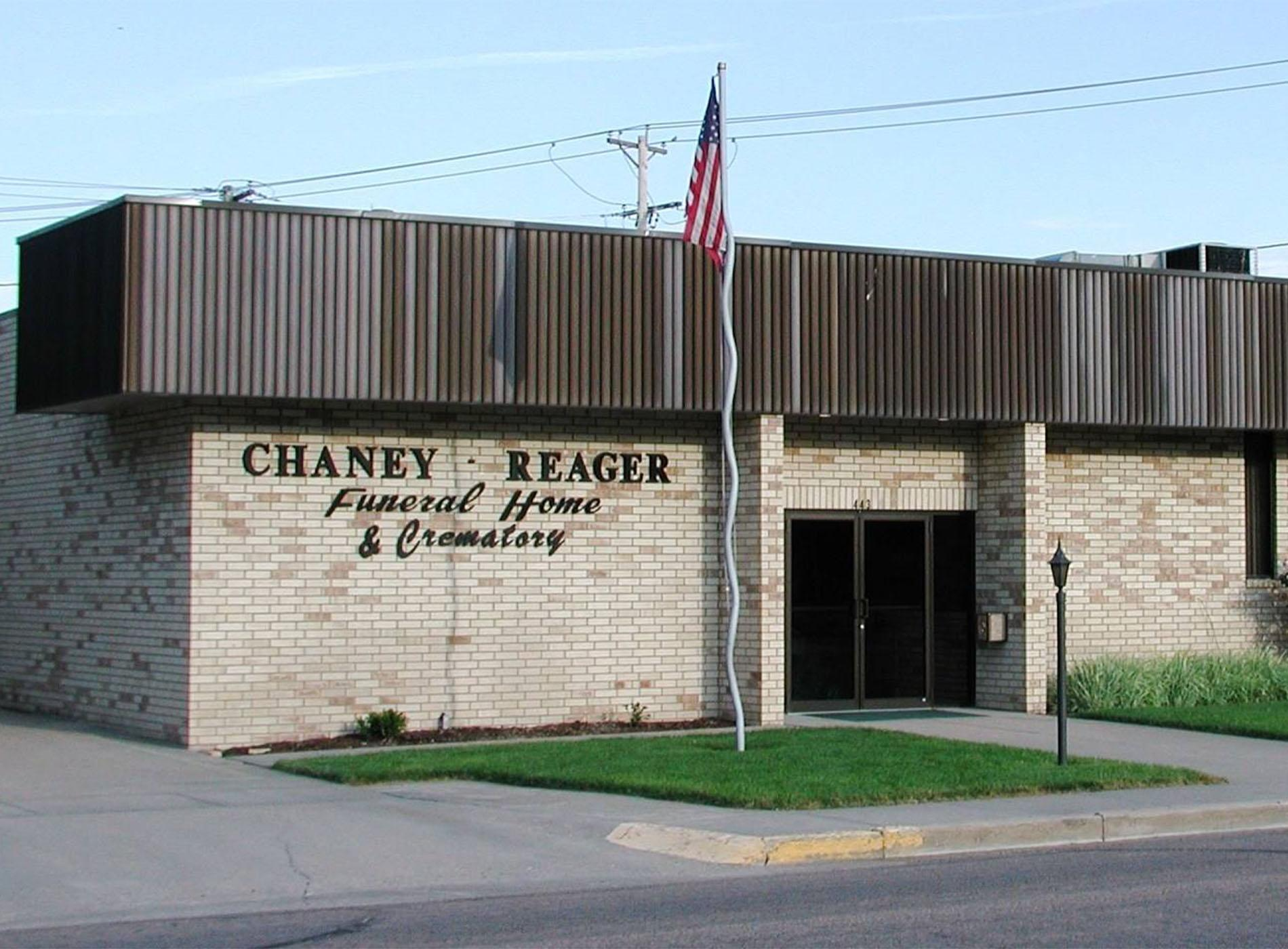 The front door of a house with a porch and plants in front of it.