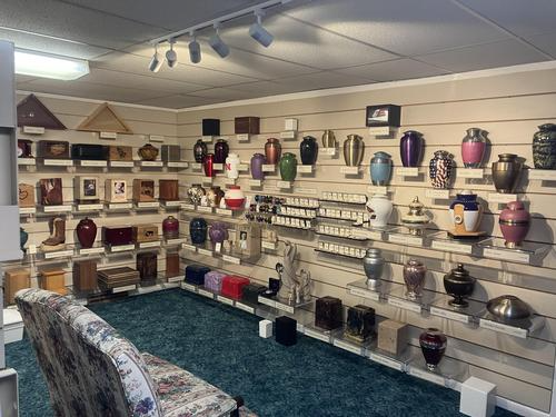 Room displaying various urns on shelves and walls; a sofa in the foreground.