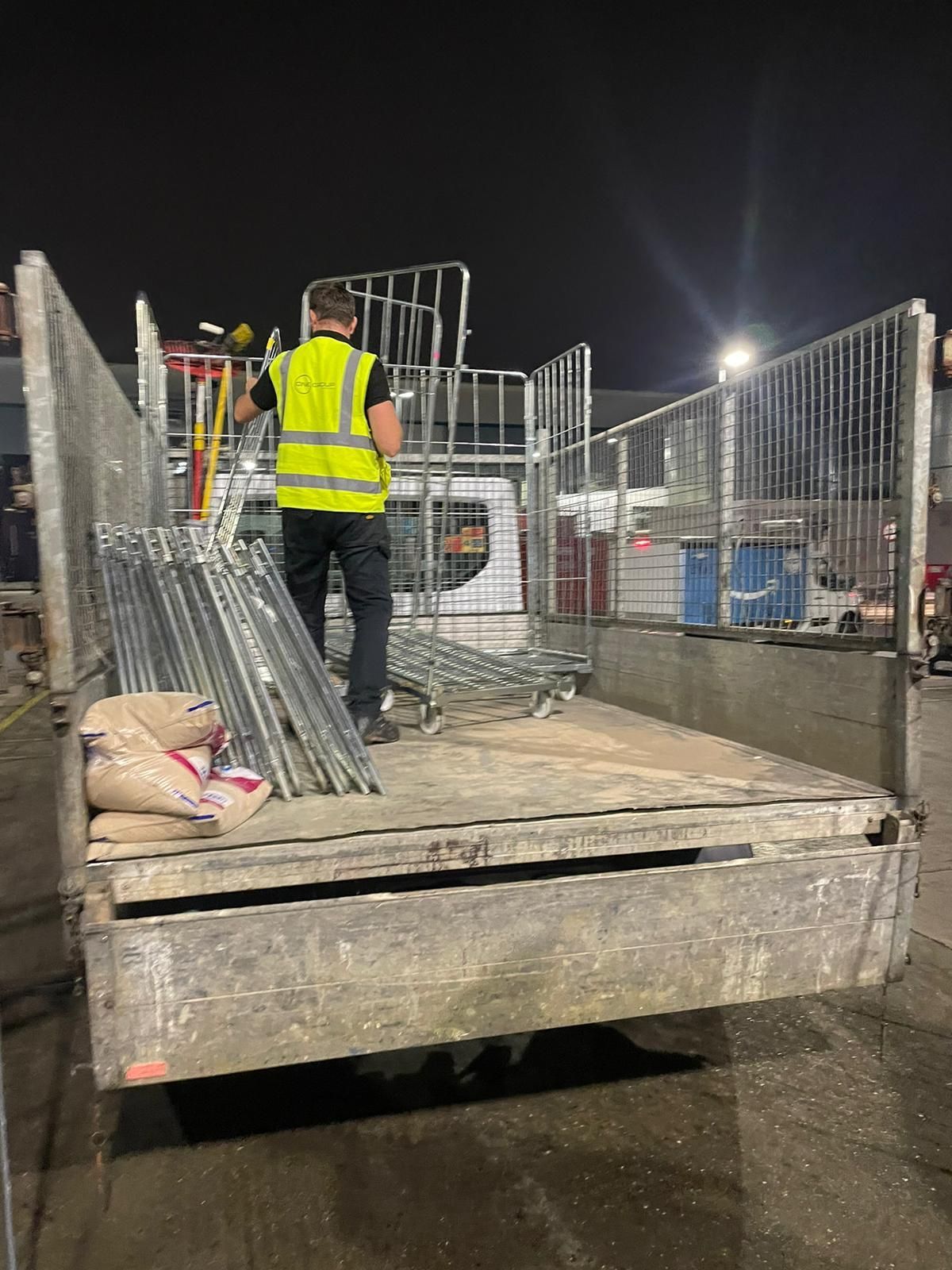 A man is standing in the back of a truck.