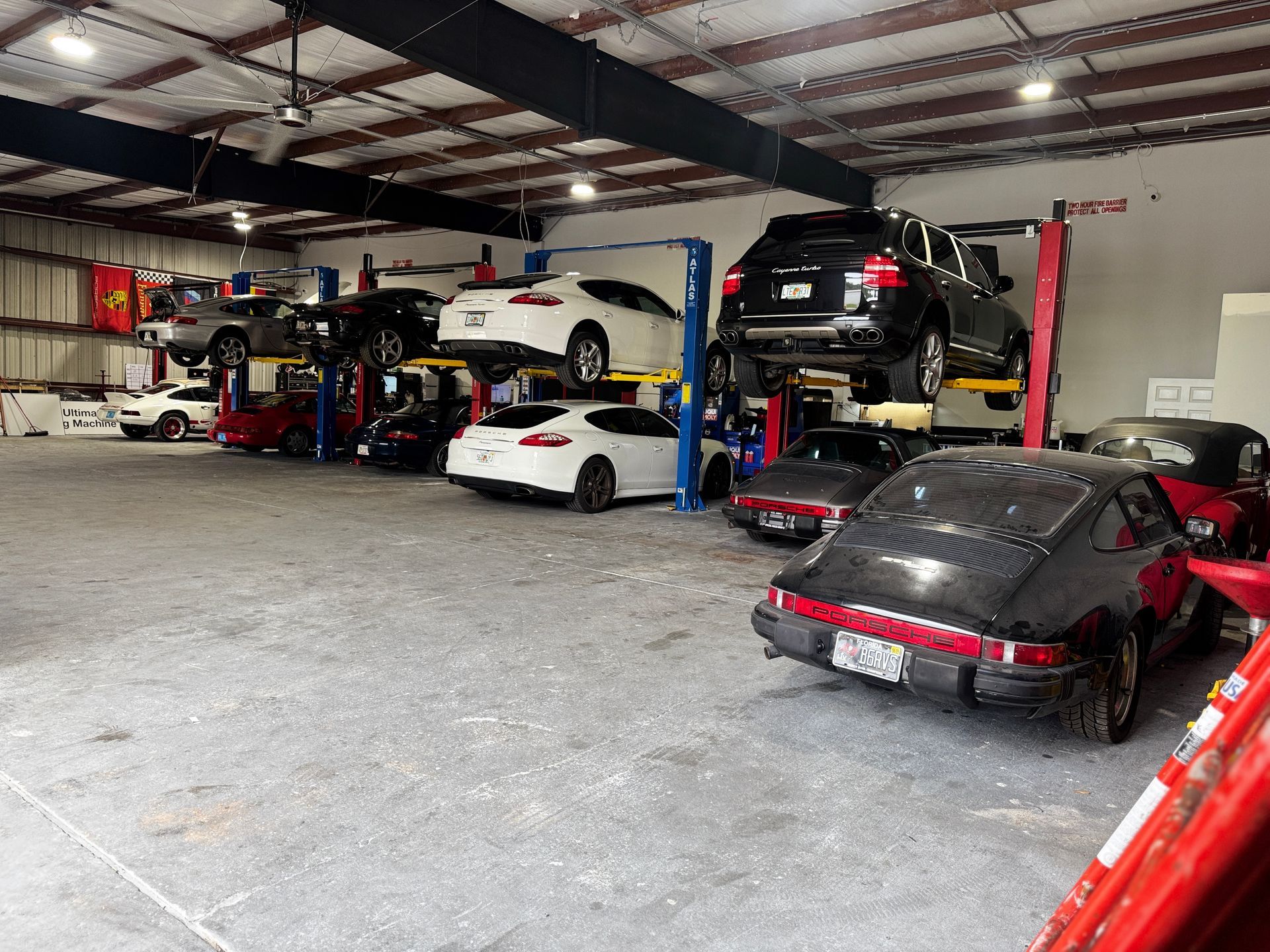 Garage interior with several cars on lifts. | Velocity Motorwerks