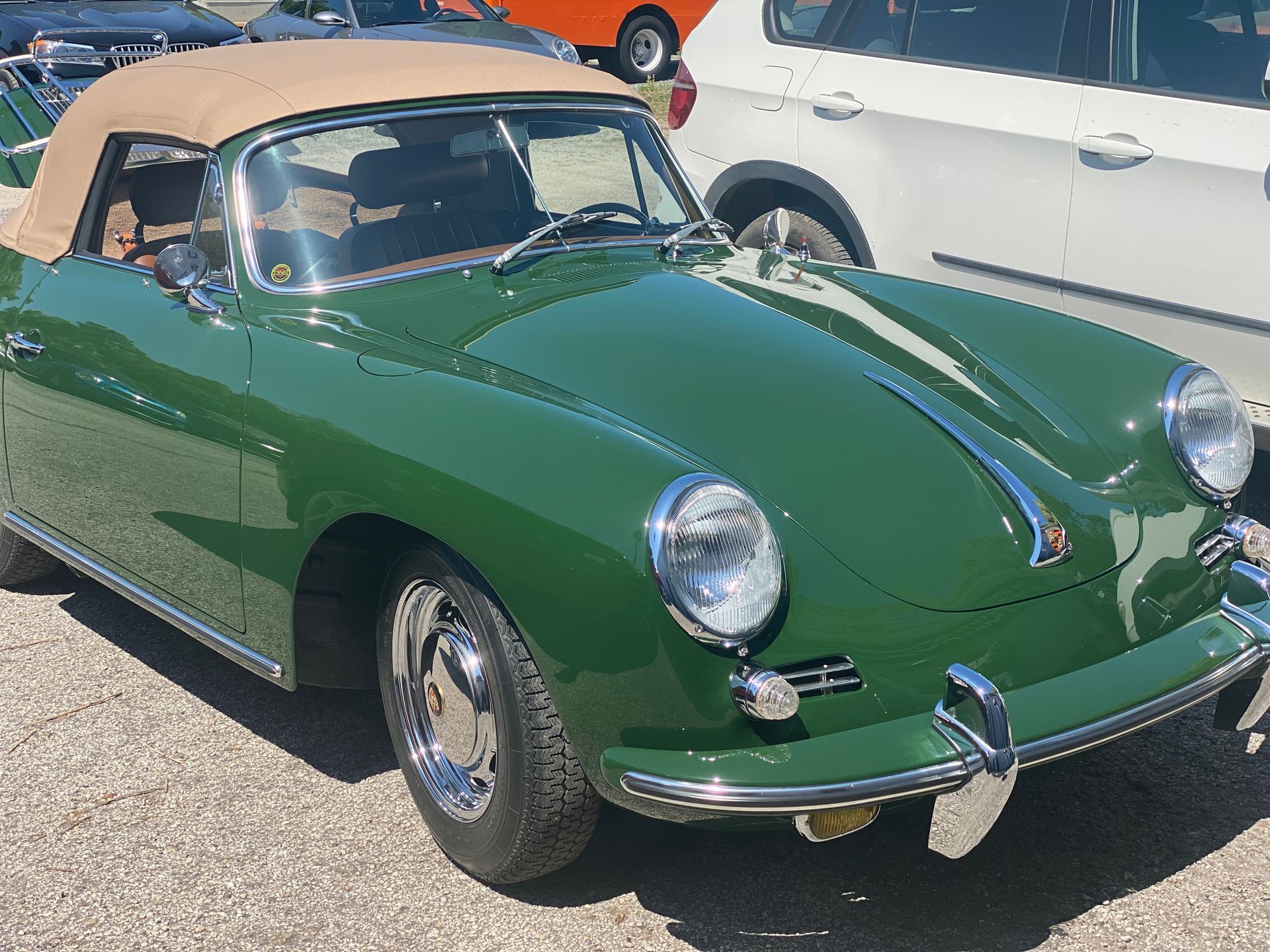 Green Porsche convertible with a tan top, parked in a lot. | Velocity Motorwerks