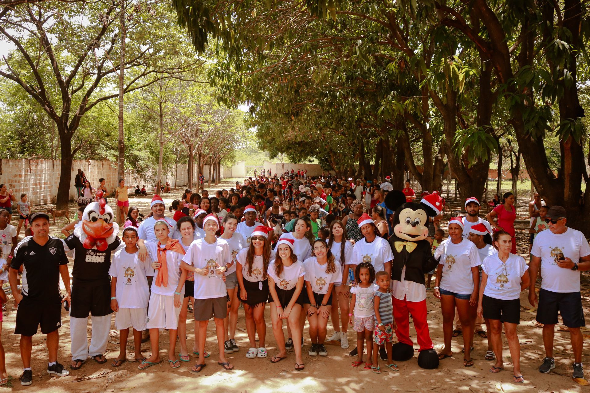 Um grupo de pessoas posando para uma foto com um mascote do Mickey Mouse