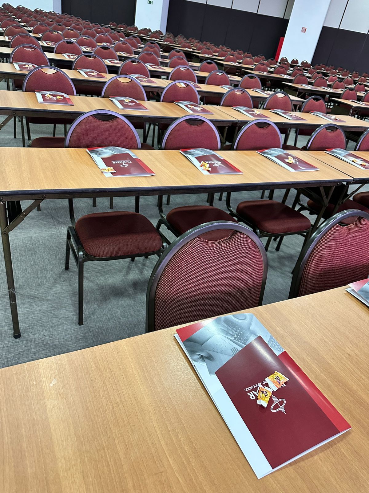 Uma sala de conferências com mesas e cadeiras e um livro sobre uma mesa.