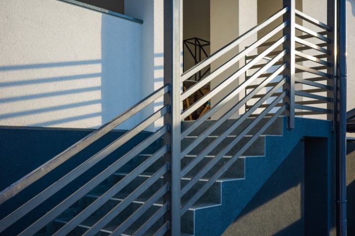 Sleek metal railing staircase against white wall