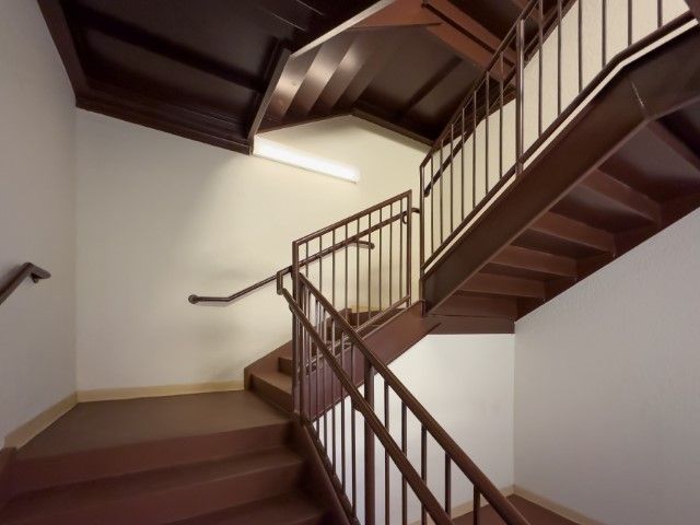 Brown exit stairs on a white building wall