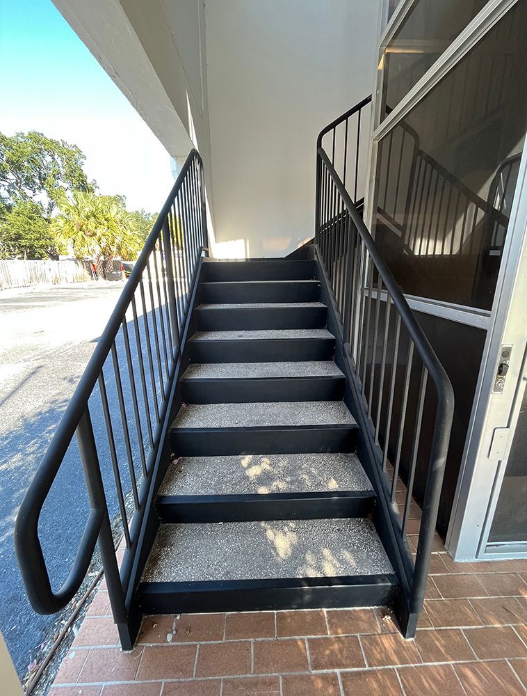 outdoor stairwell with black pipe handrails in mixed-use building
