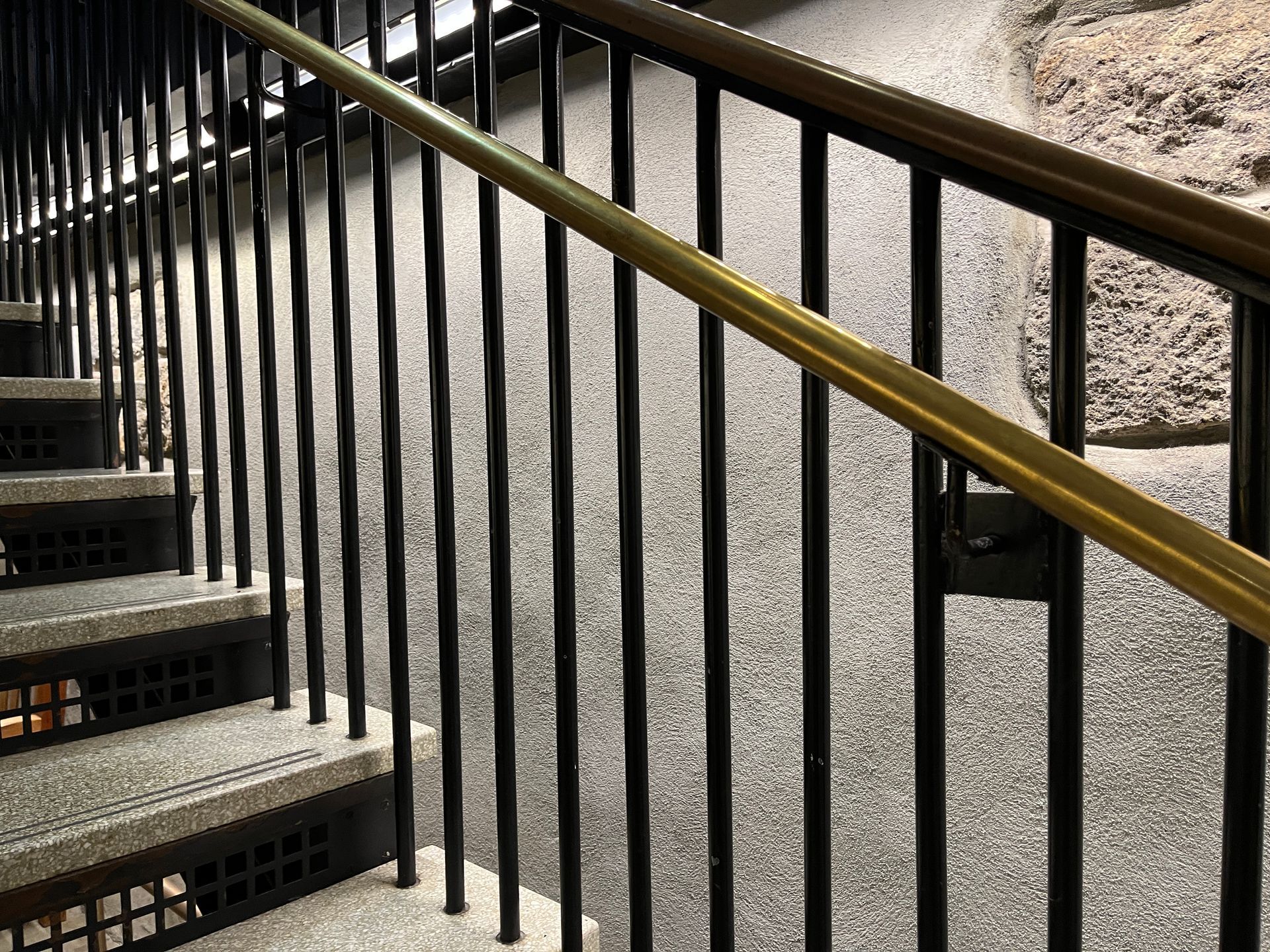 metal handrail, black and gold with cement tread steps