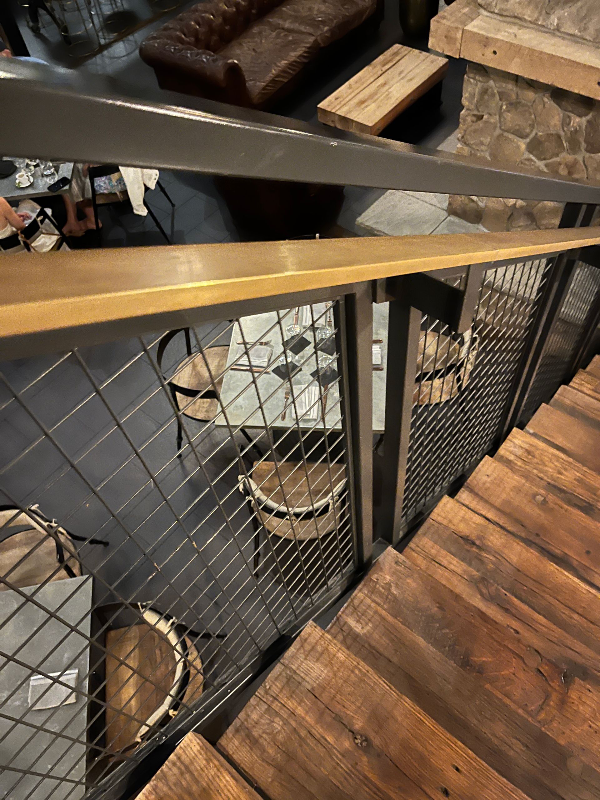restaurant metal railing with mesh infill grid and wood treads