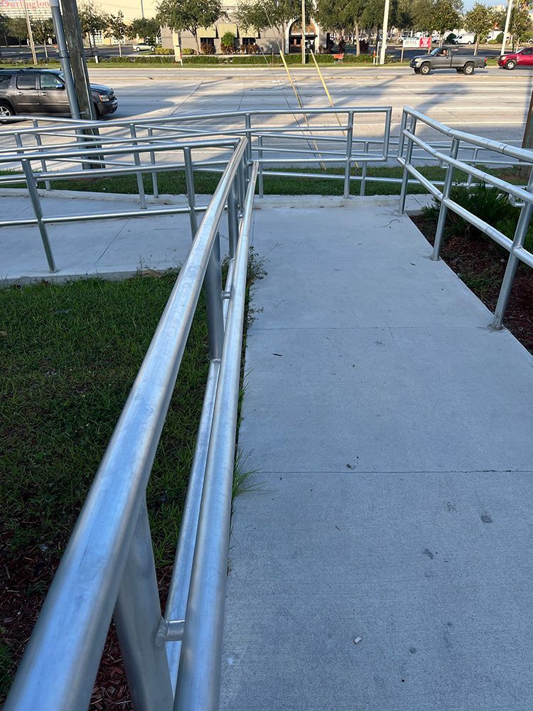 silver steel pipe railings with handrails along the ramp