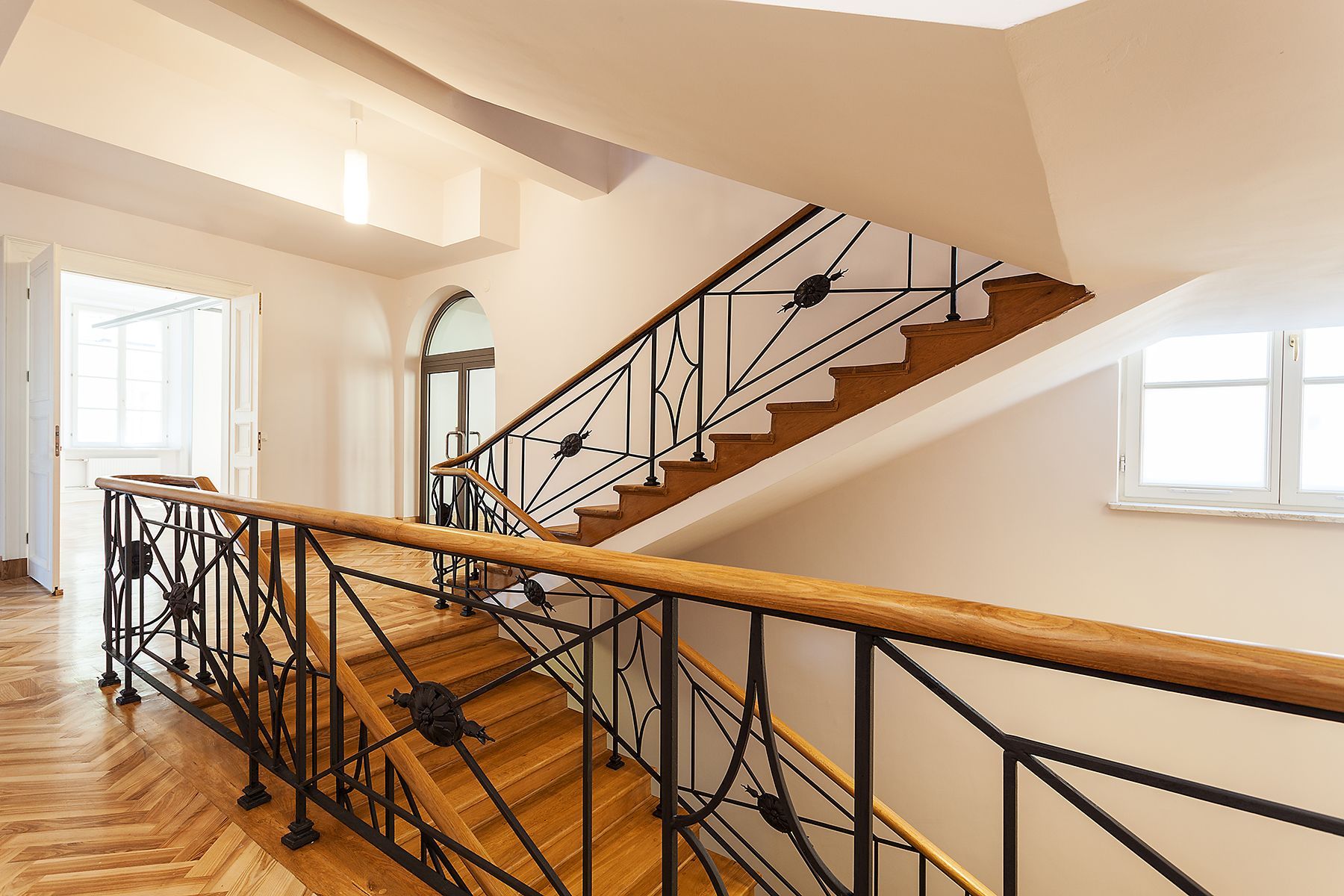 wrought iron and wood railing in large indoor staircase with custom design