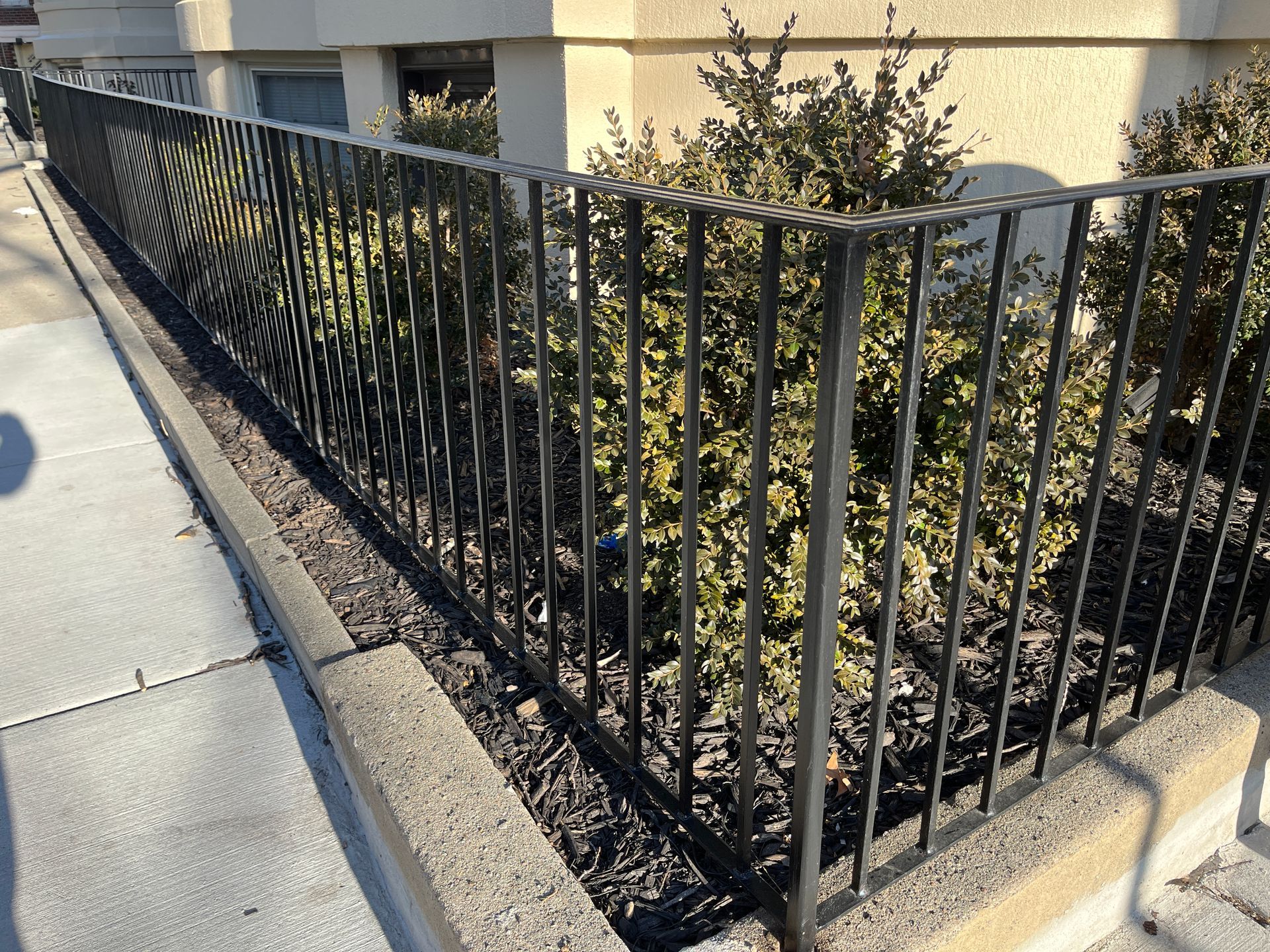 wrought iron fence around property along sidewalk