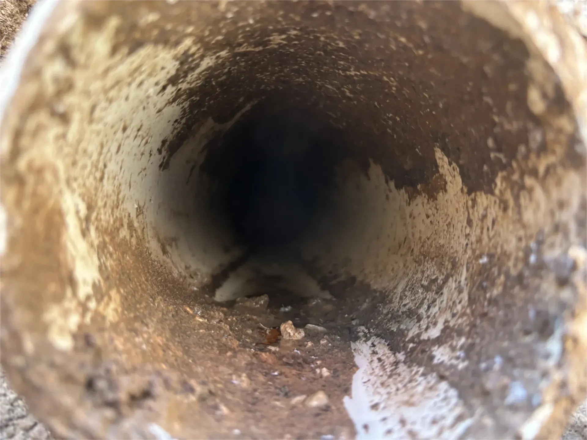 A close up of a dirty pipe with a hole in the middle.