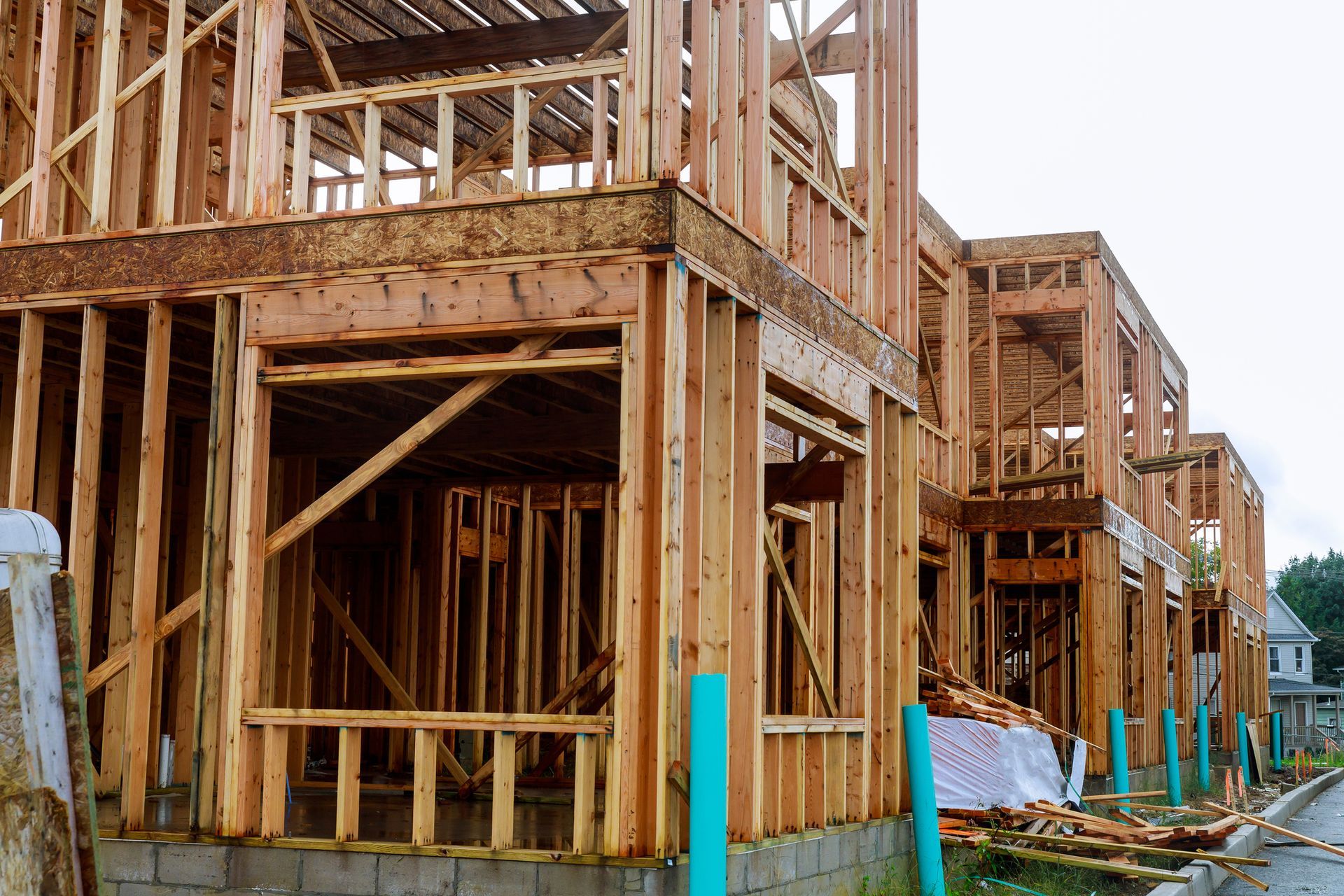 A row of wooden houses are being built in a residential area.