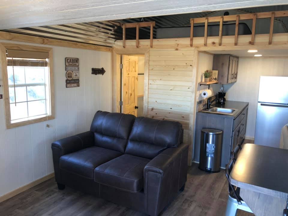 Interior of cabin at Creek Side Resort. Includes couch and a kitchen. 