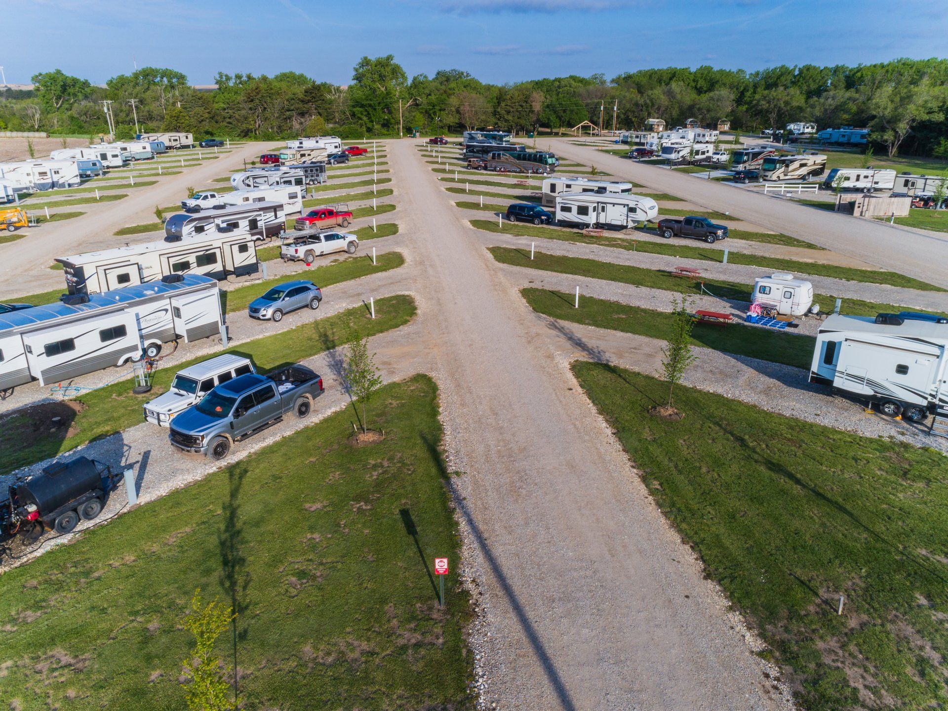 Campers and RVs on gravel pull through at Creek Side Resort in Hays, Kansas