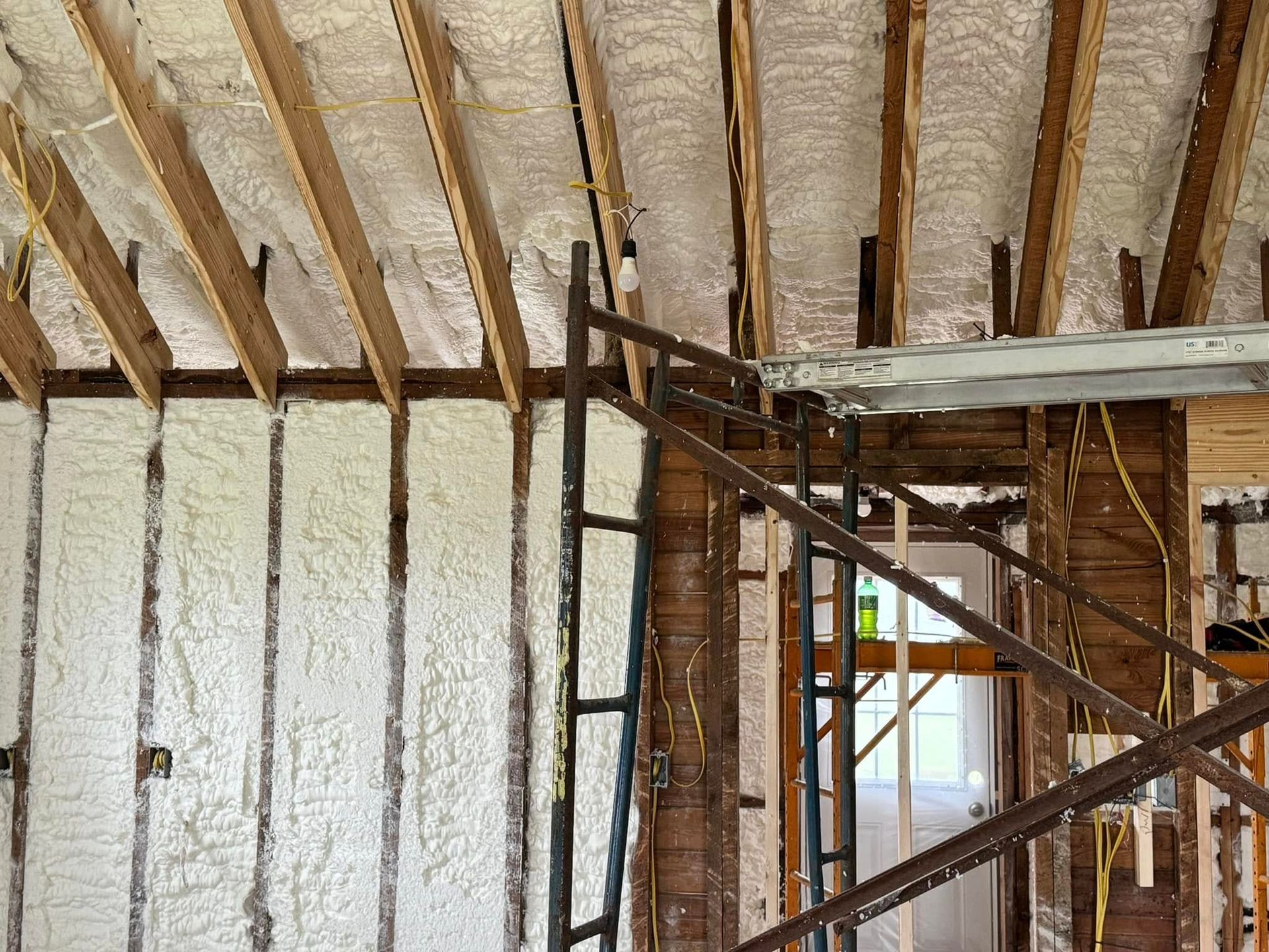 A house is being built with scaffolding and foam on the walls.