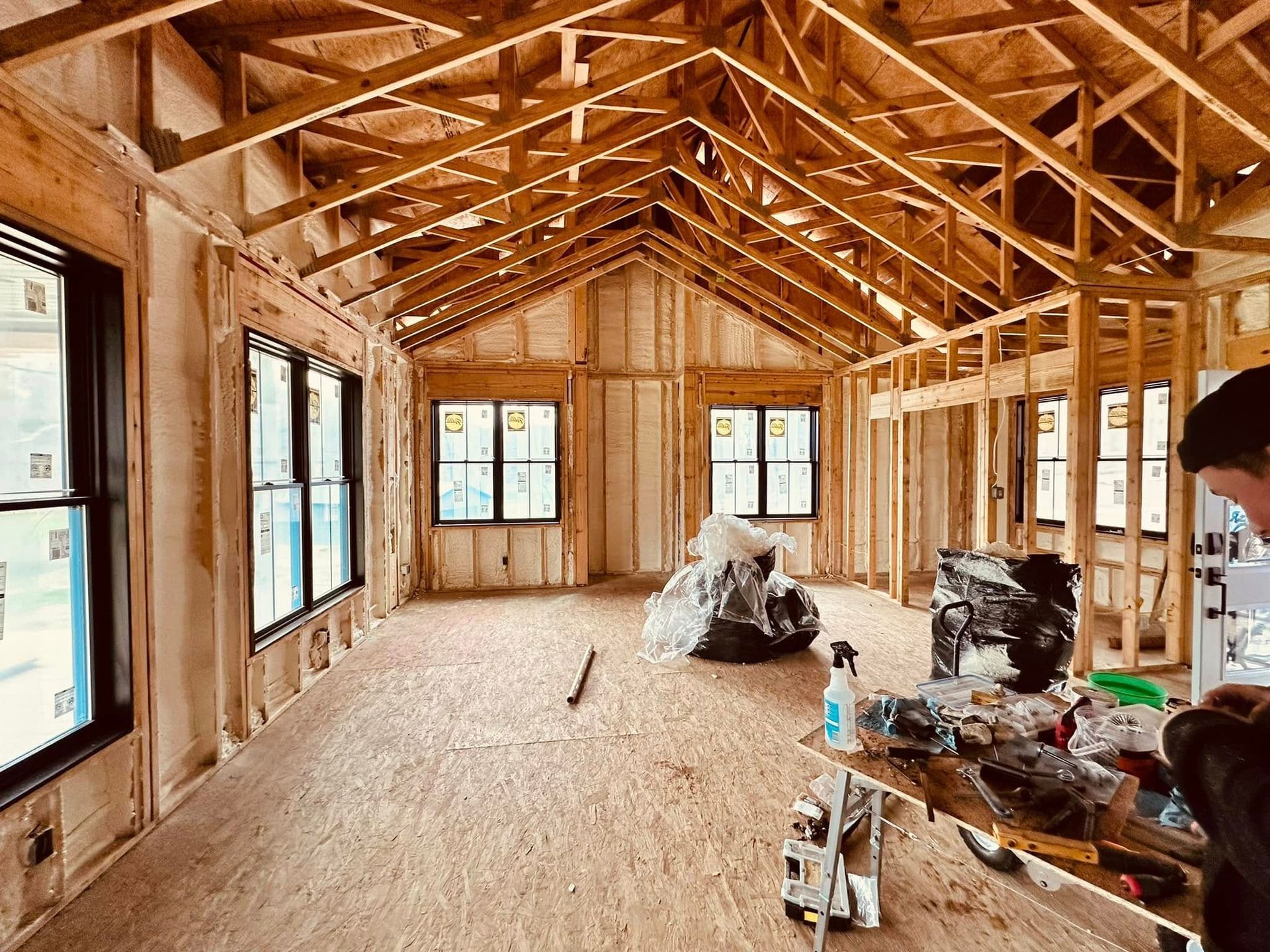 A man is standing in the middle of a room under construction.