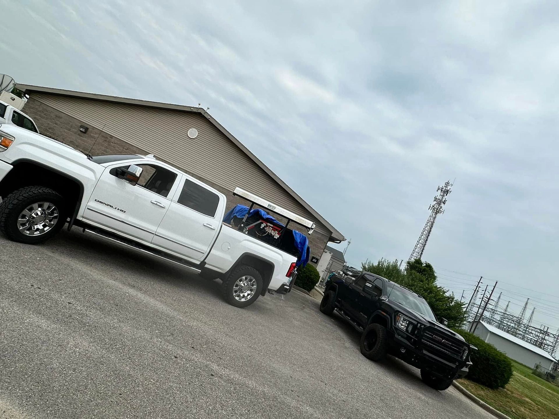 Two trucks are parked next to each other in front of a building.
