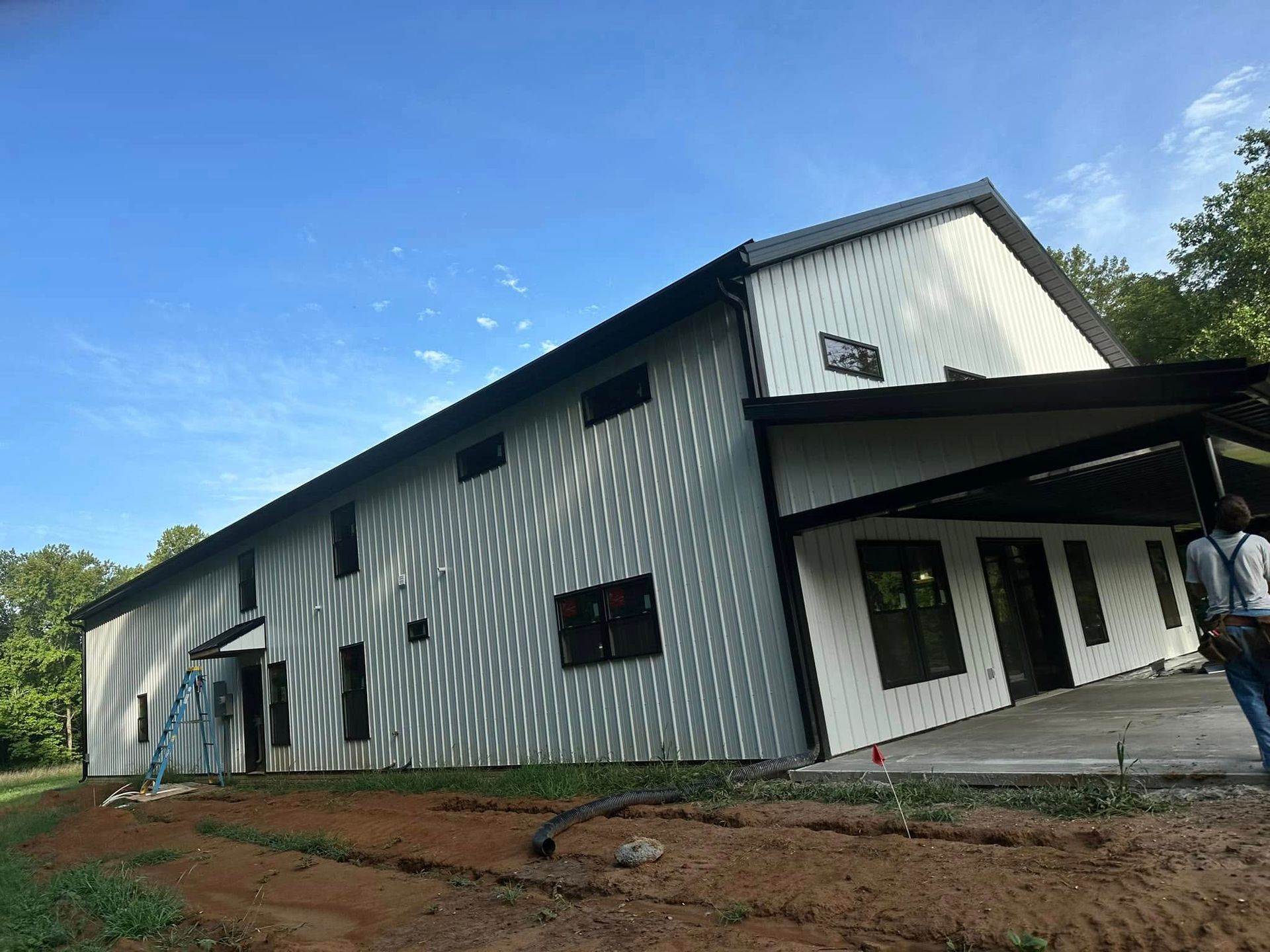 A man is standing in front of a large white building.