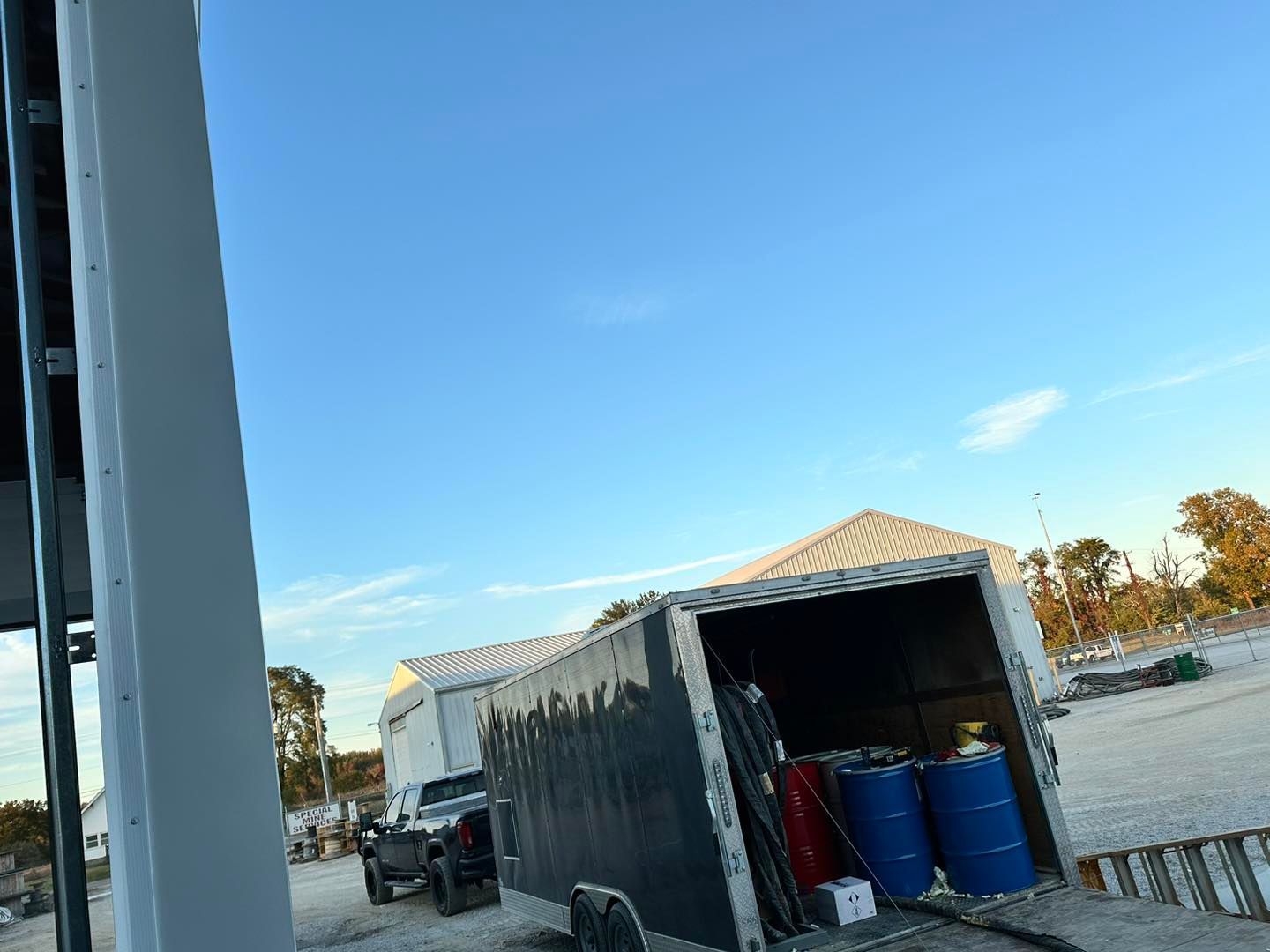 A trailer with two barrels in it is parked in a parking lot.