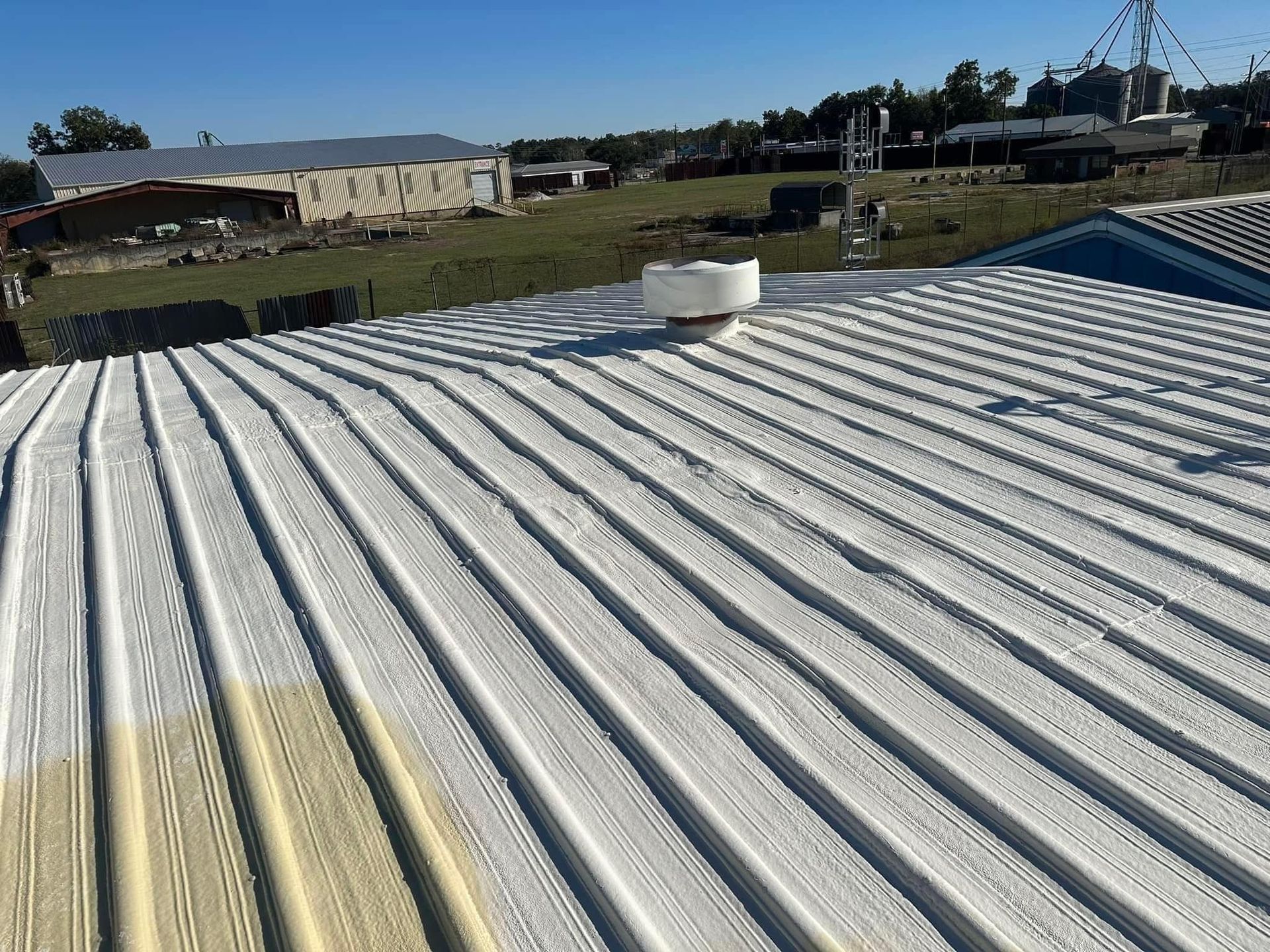 The roof of a building has been painted white.