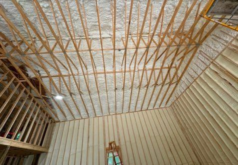 A room with a ceiling that is being insulated with spray foam.