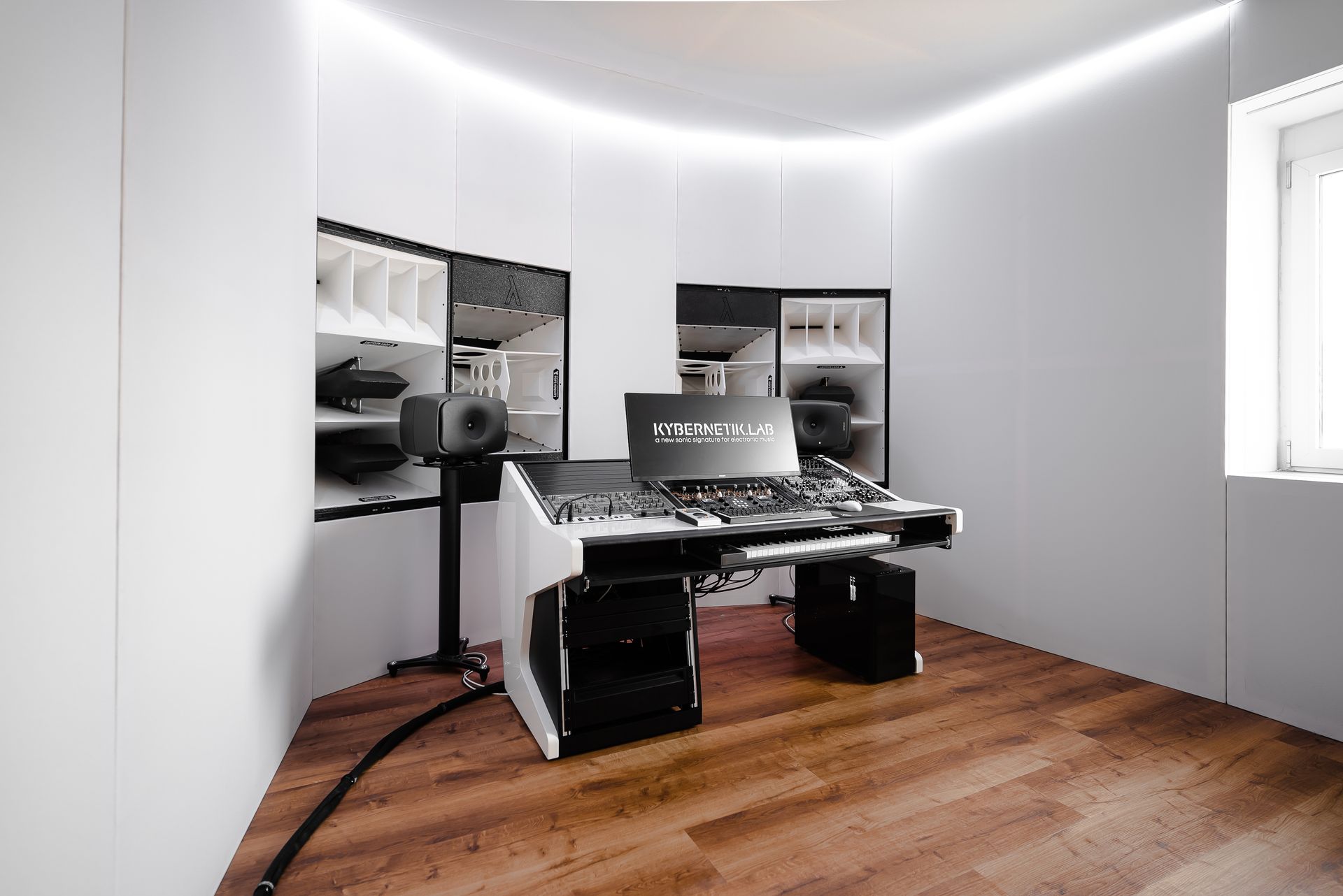 Weißes Aufnahmestudio mit Laptop, Ausrüstung und Holzböden.