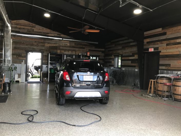 A black car is parked inside of a garage