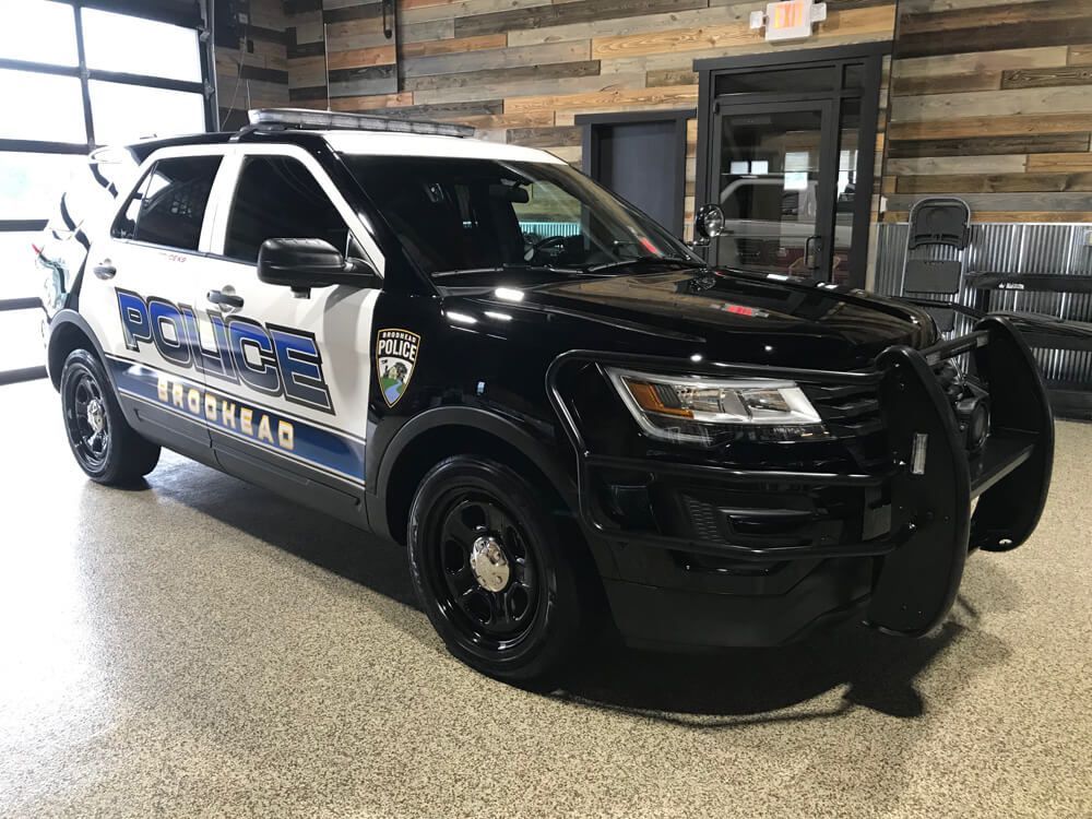 A black and white police car is parked in a garage.