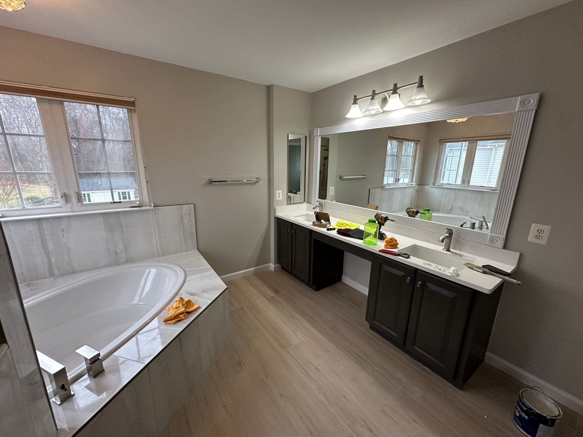 A bathroom with a tub , sink and mirror.