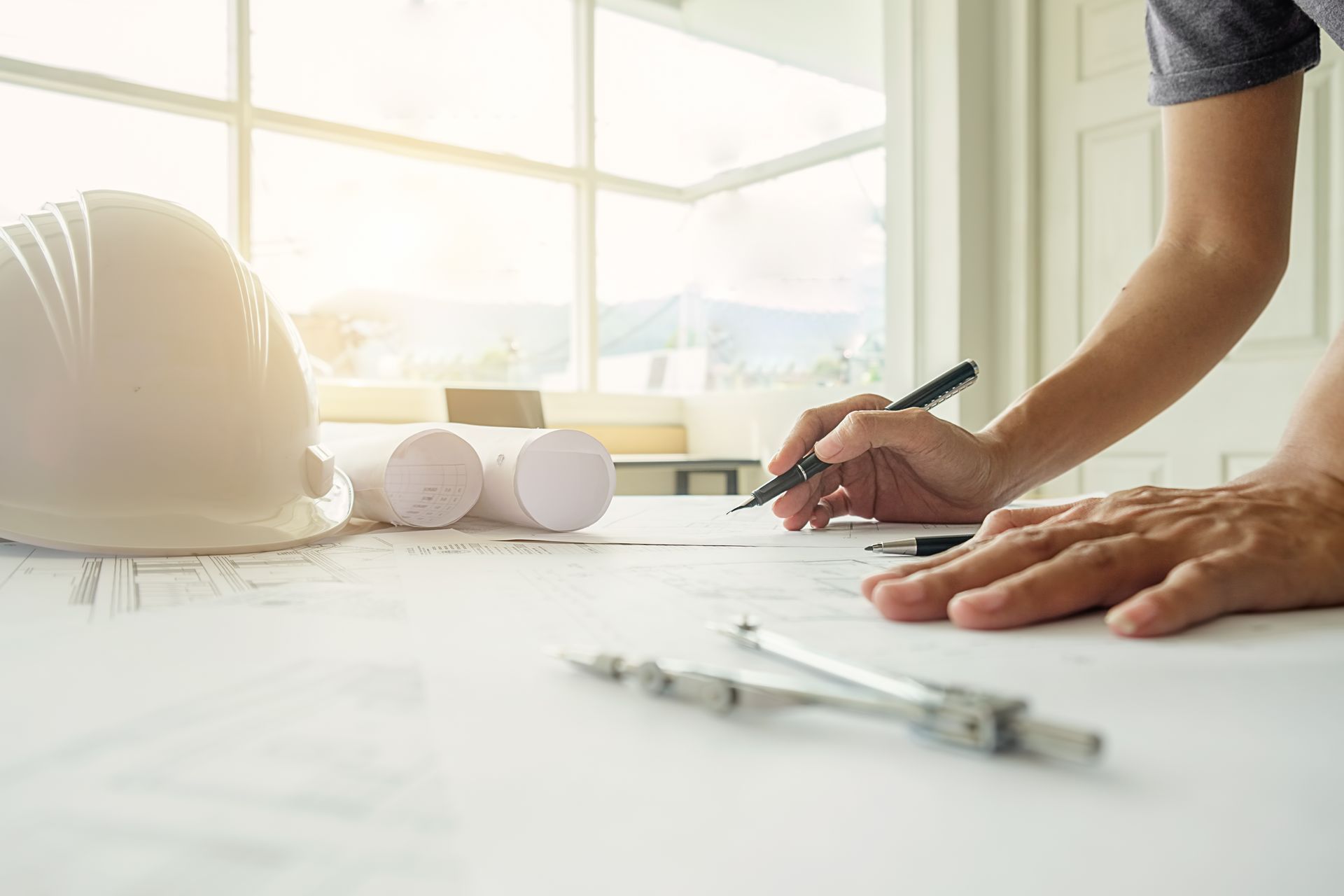 A person is sitting at a table writing on a piece of paper.