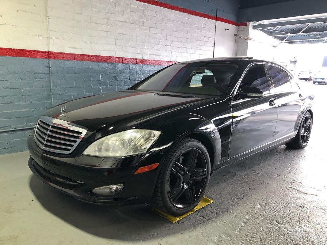 Black Mercedes-Benz sedan parked in a garage.