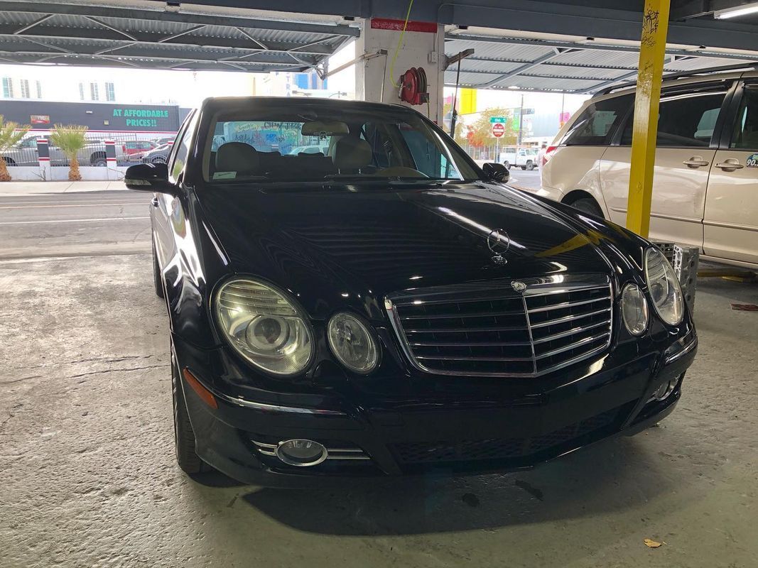 Black Mercedes-Benz sedan parked in an open garage.