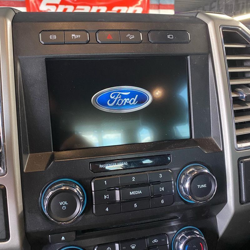 Ford truck dashboard with center console screen displaying the Ford logo.