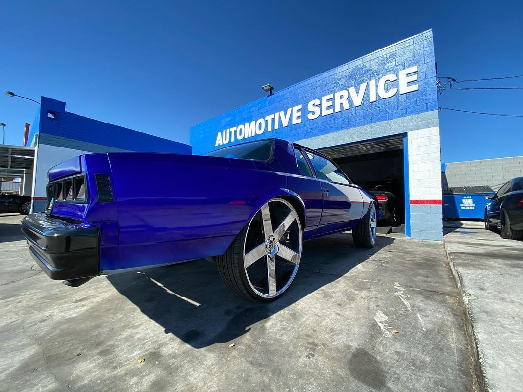 Blue custom El Camino parked in front of an automotive service shop.