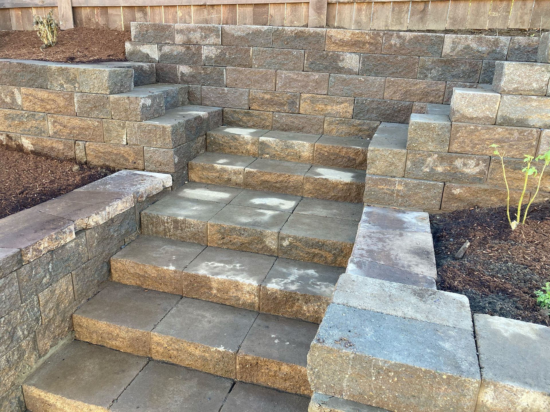 A set of stairs leading up to a stone wall.