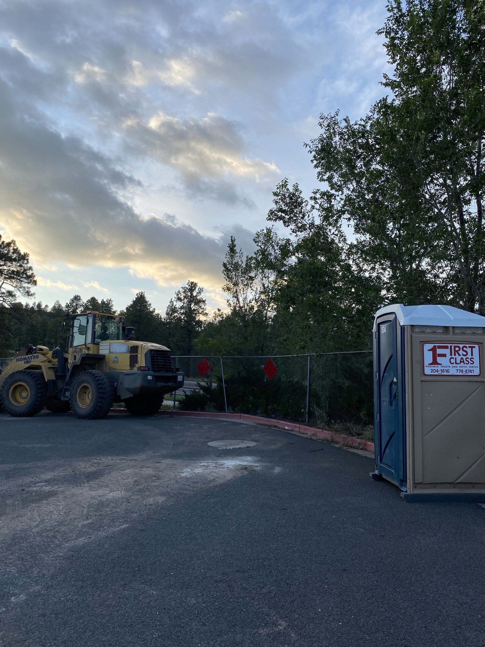 Portable restroom near a yellow truck | Flagstaff, AZ | First Class Sanitation