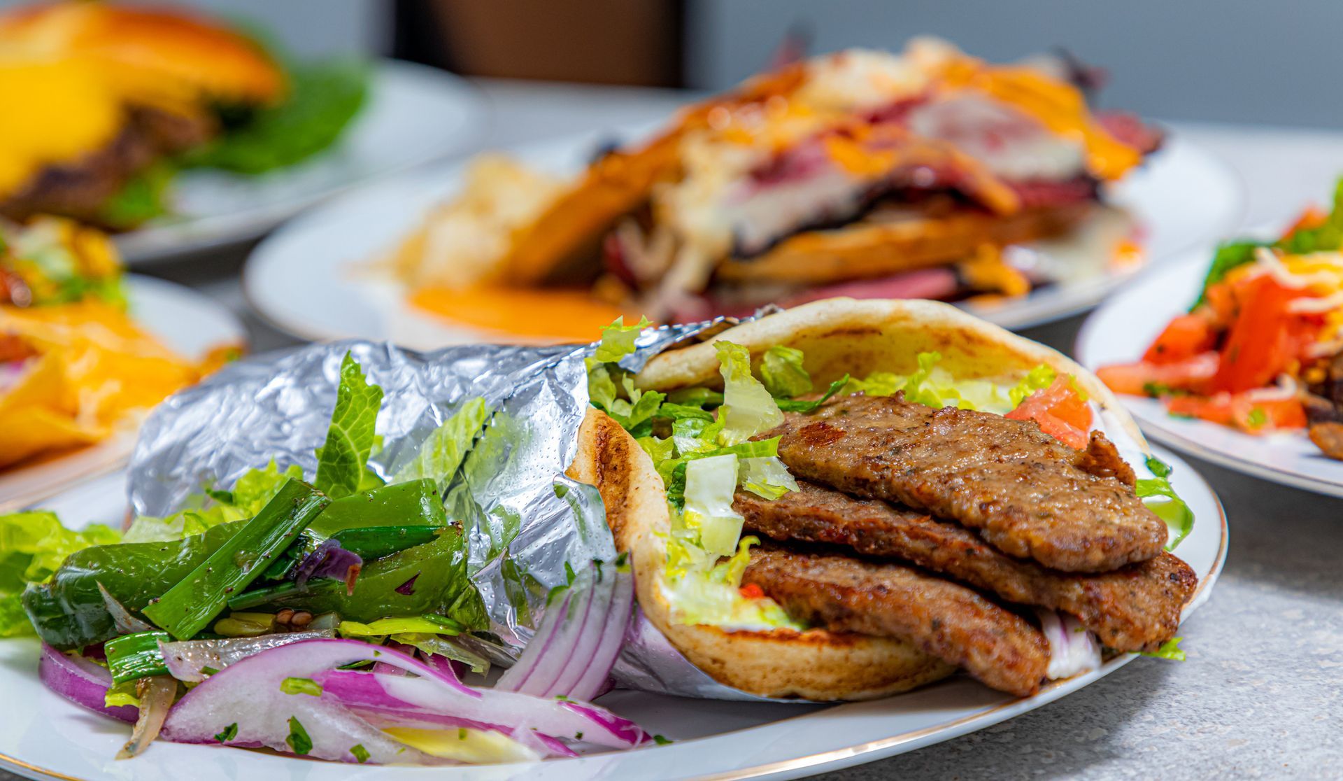 A plate of food with a gyro on it on a table.