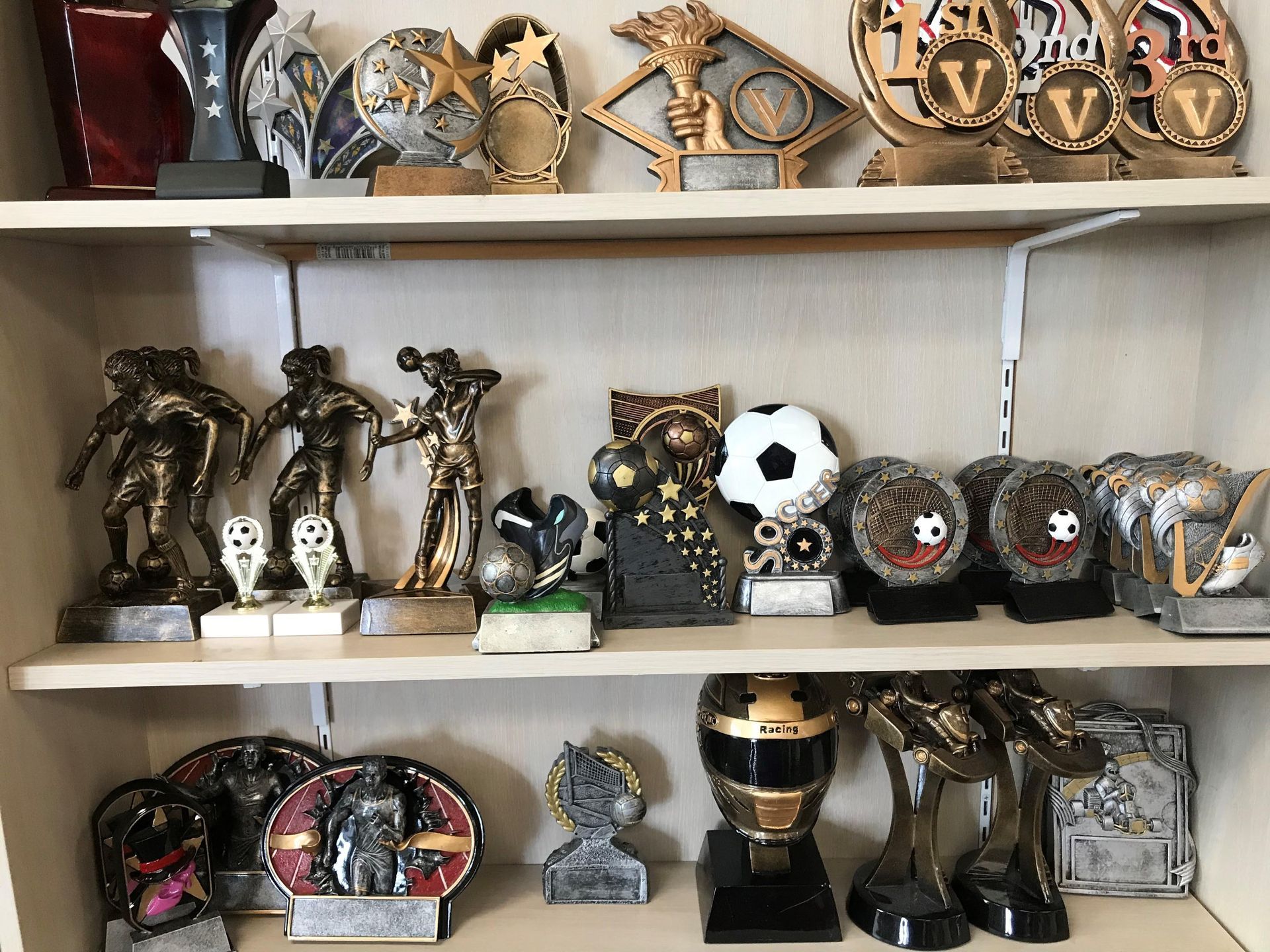 A shelf filled with a variety of trophies and plaques