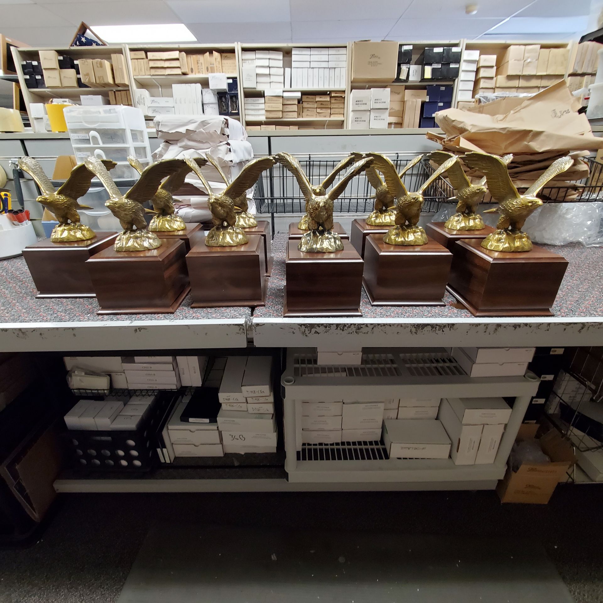A row of eagle trophies are lined up on a table