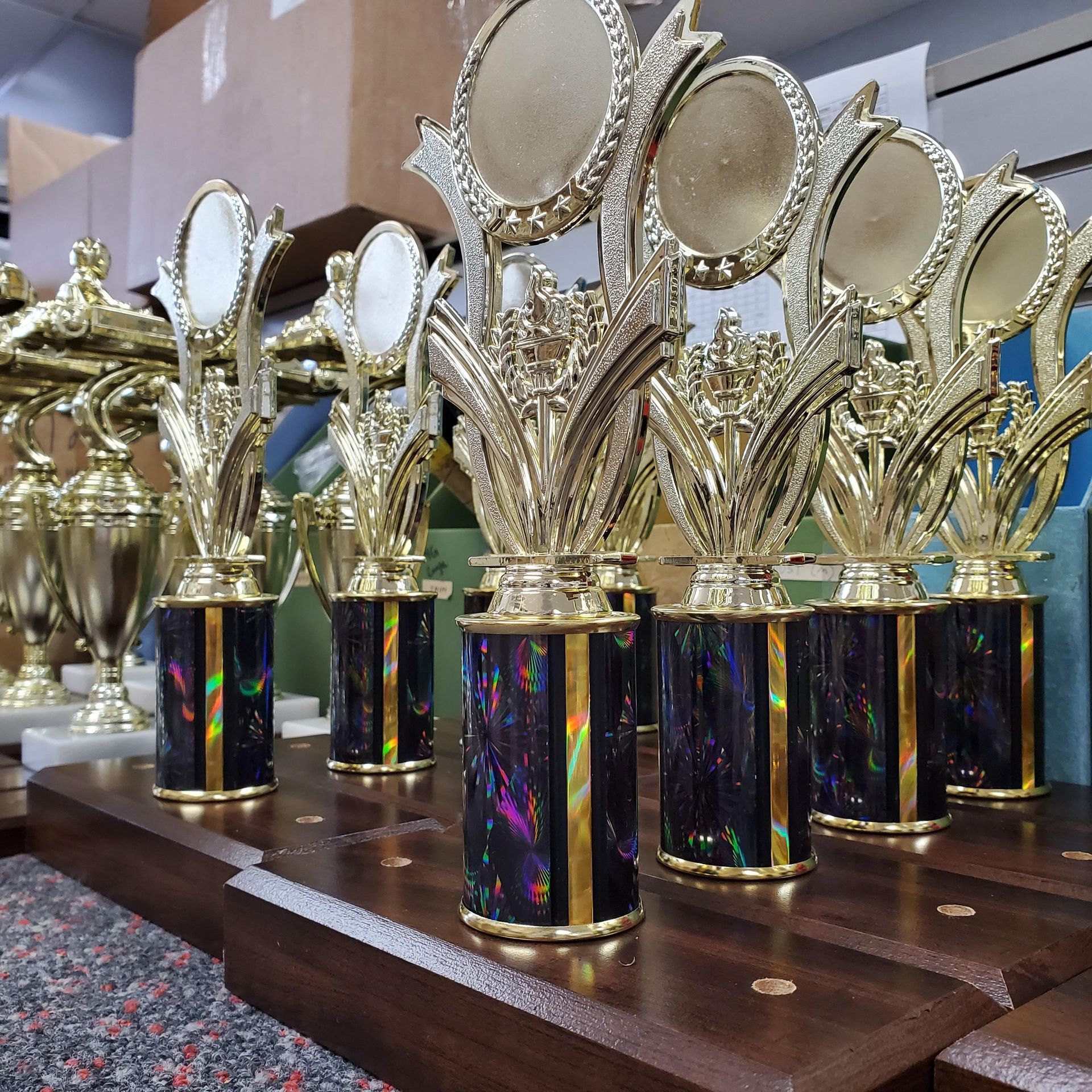 A bunch of trophies are lined up on a table