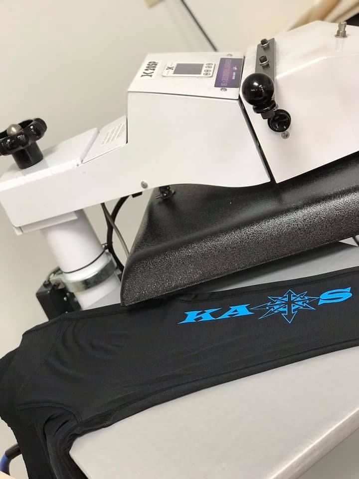 A machine that is making a shirt with the word ka on it
